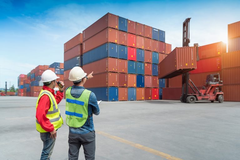 Foreman control loading Containers box from Cargo freight ship in Warehouse shipping transportation concept. Using a Private mobile Network.