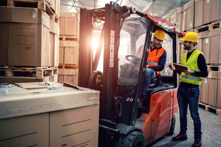 Een werkende man met een tablet in zijn linker hand en een portofoon in zijn zak.