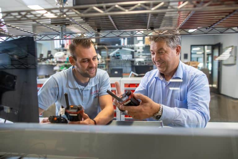 Engineer Flash employees looking at a two-way radio